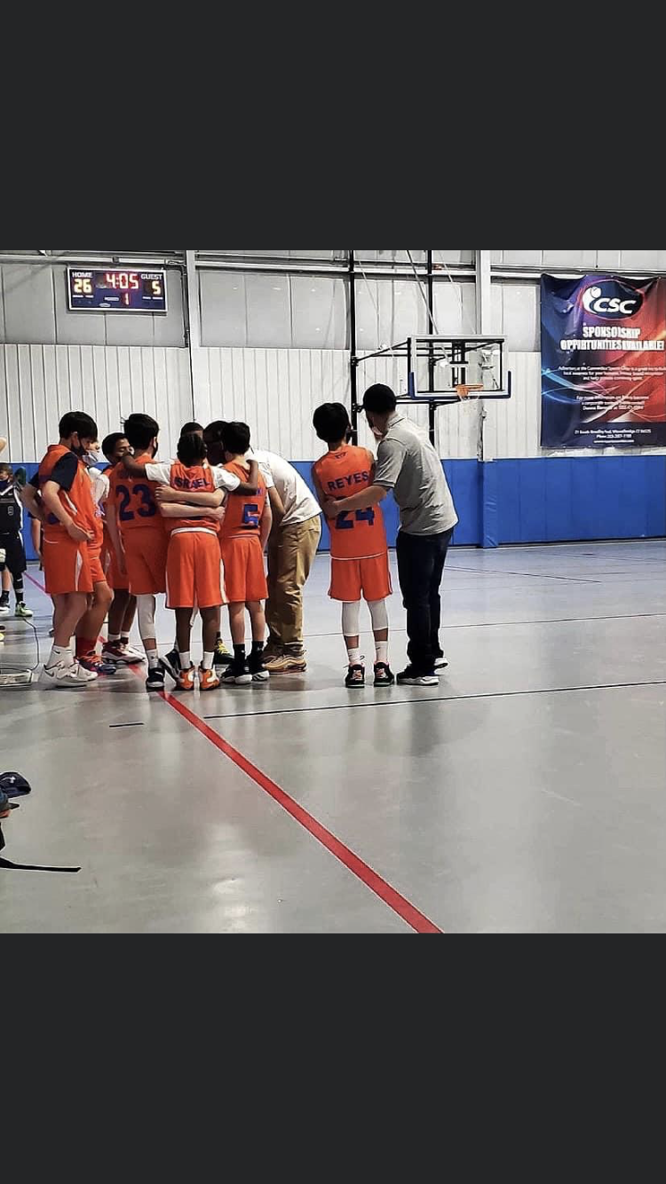 Coach Muni in a game-day team huddle