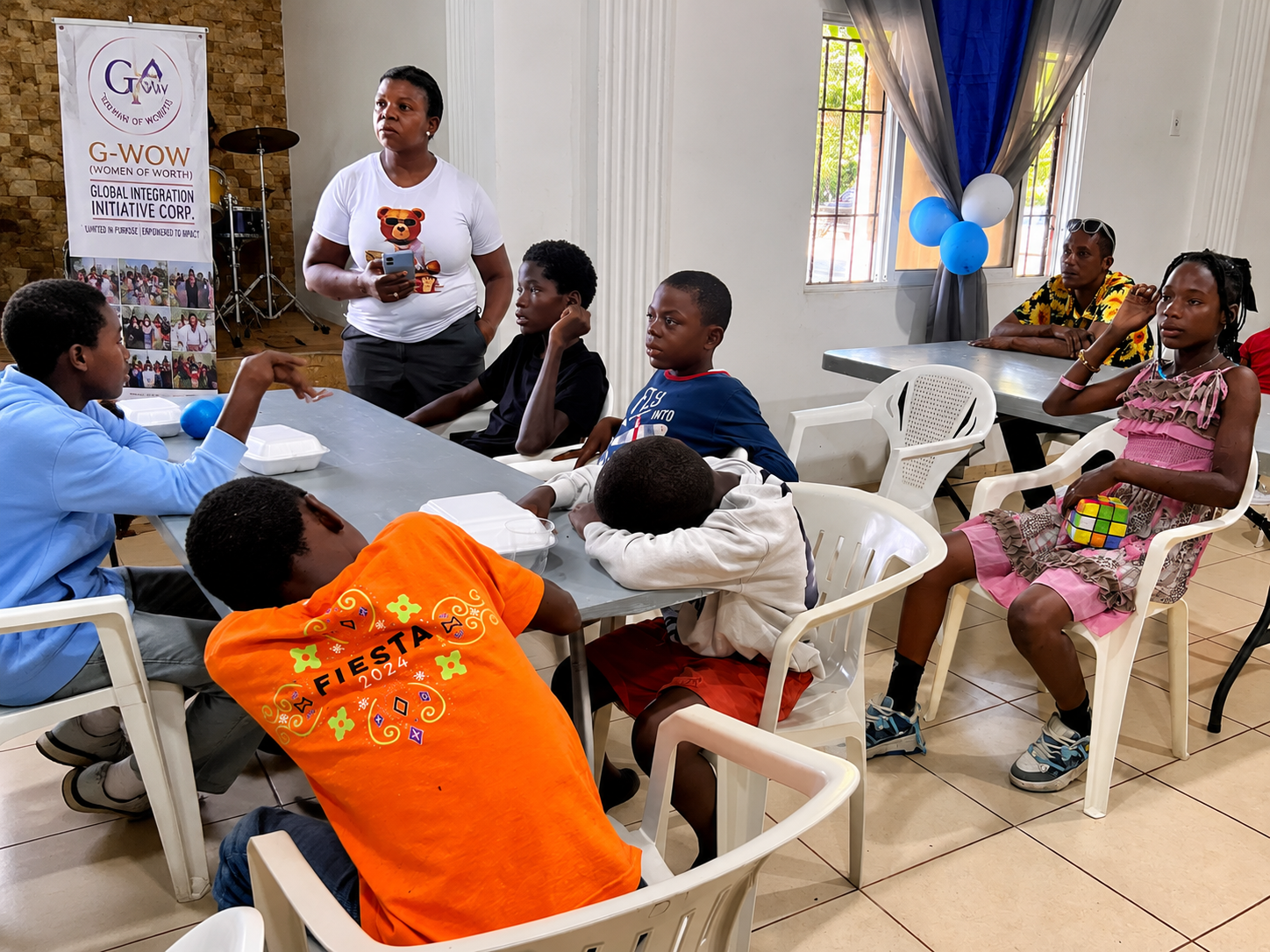 Children and organizers gathered around a table at a community activity