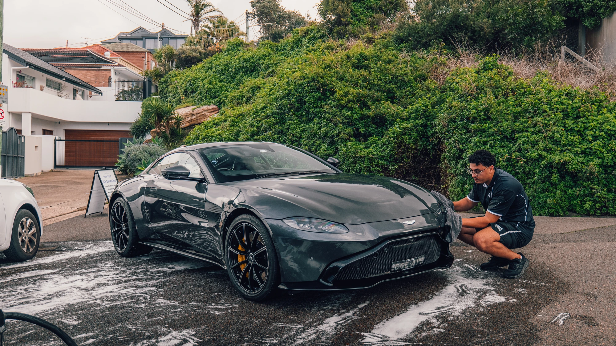 Detailer hand-drying an Aston Martin Vantage