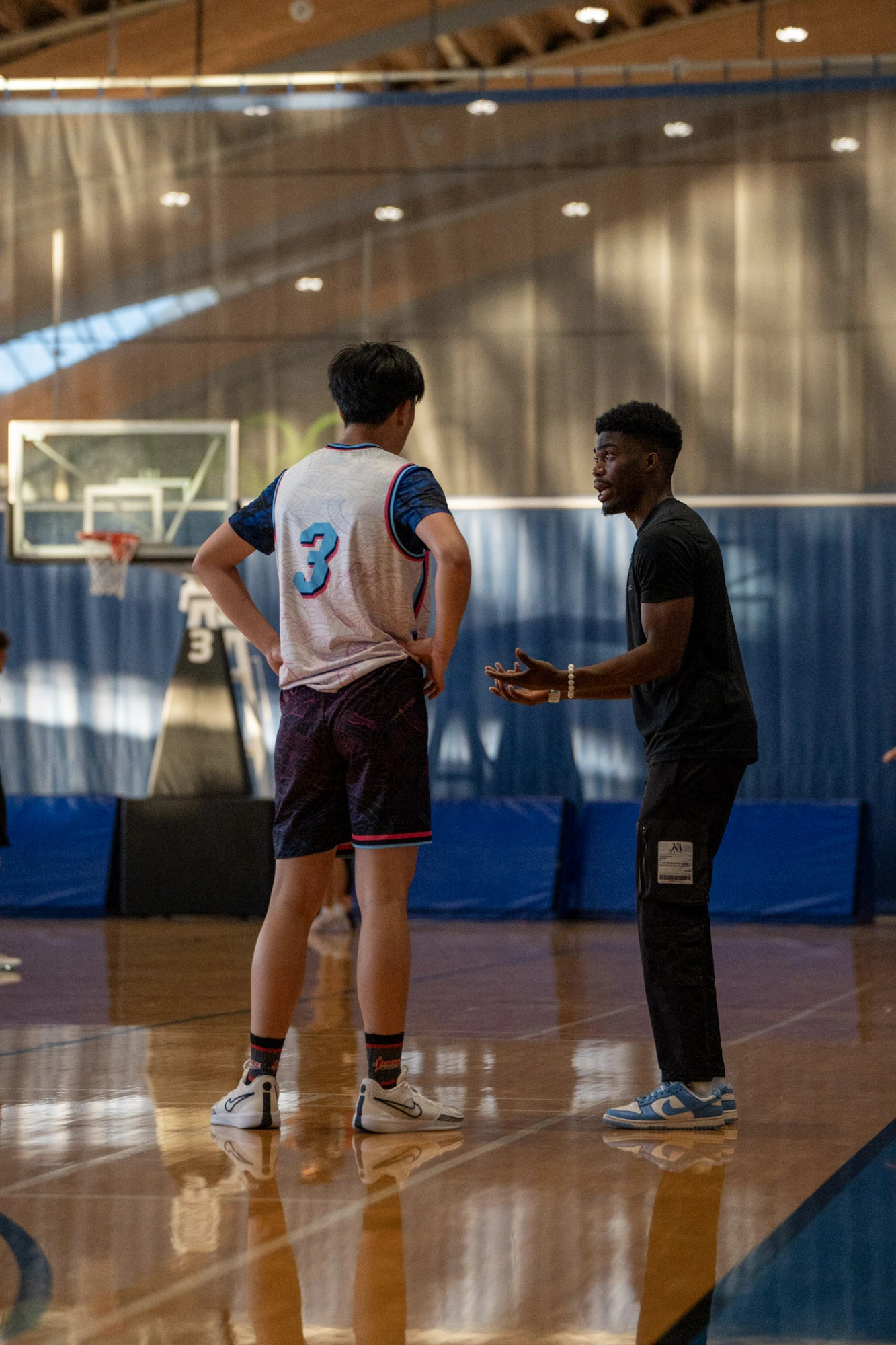 Coach Elete coaching a player one-on-one on the court