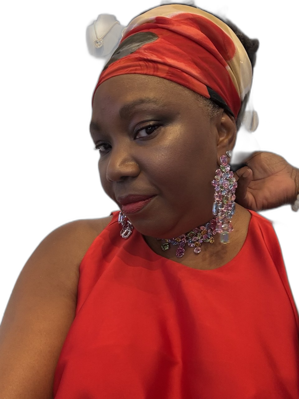 Clan Mother Shifa in red top with crystal earrings, radiant complexion glowing